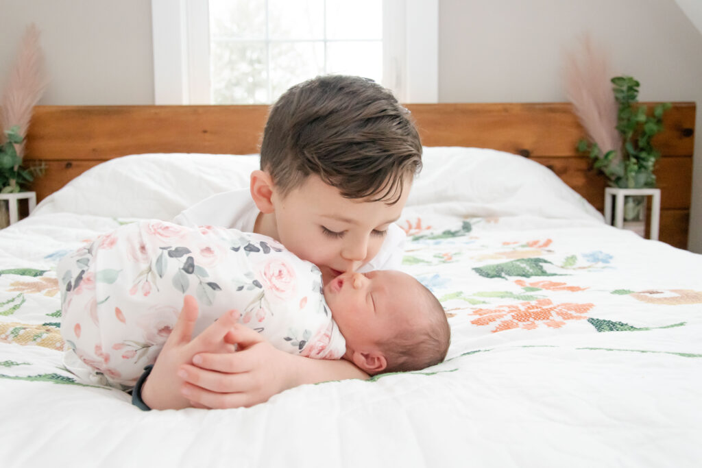 Boy kissing his baby sister