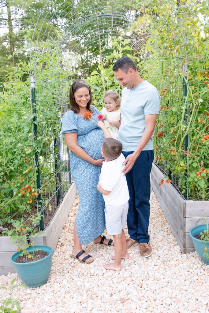 Husband and wife in blue. In the garden for there maternity sesison.