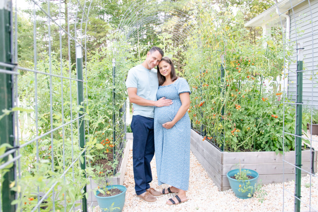 Husband and wife in blue. In the garden for there maternity session.