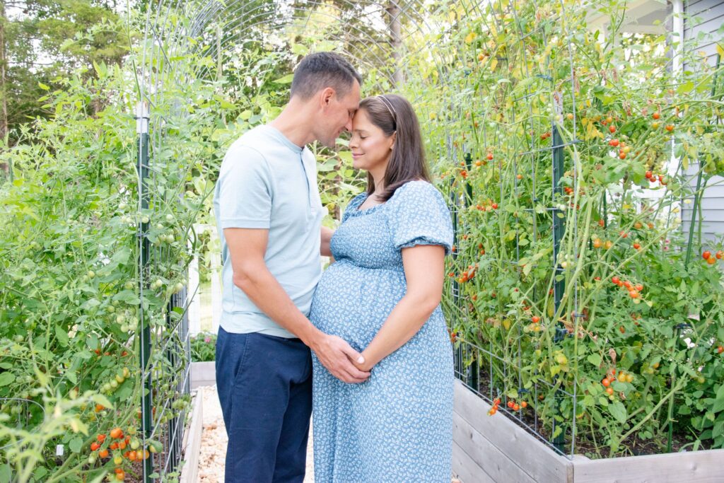 Husband and wife in blue. In the garden for there maternity session.