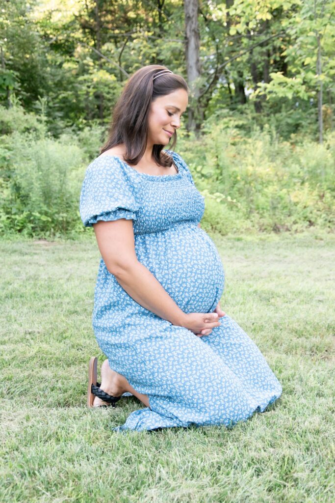 Pregnant mom in a blue dress with white flowers.