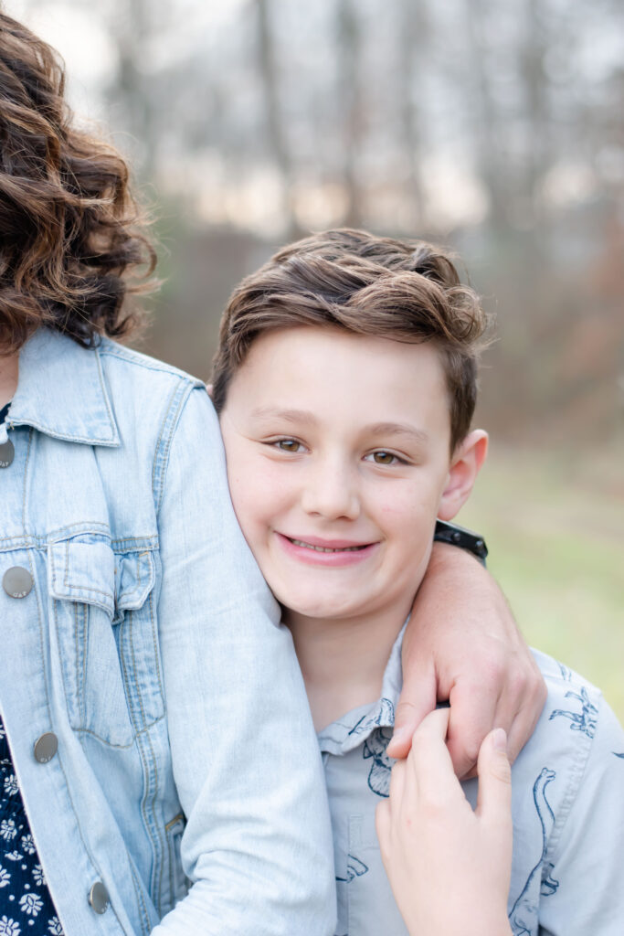 Boy looking at camera next to mom.