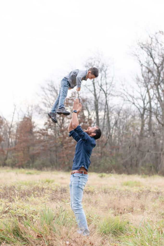 dad throwing boy into the air.