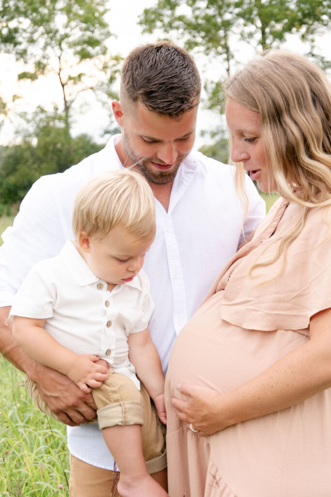 Son looking at moms maternity belly.