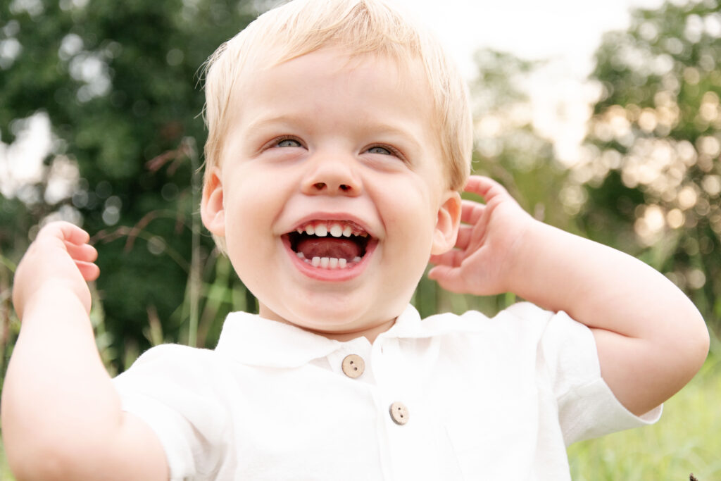 Toddler looking at camera and laughing.