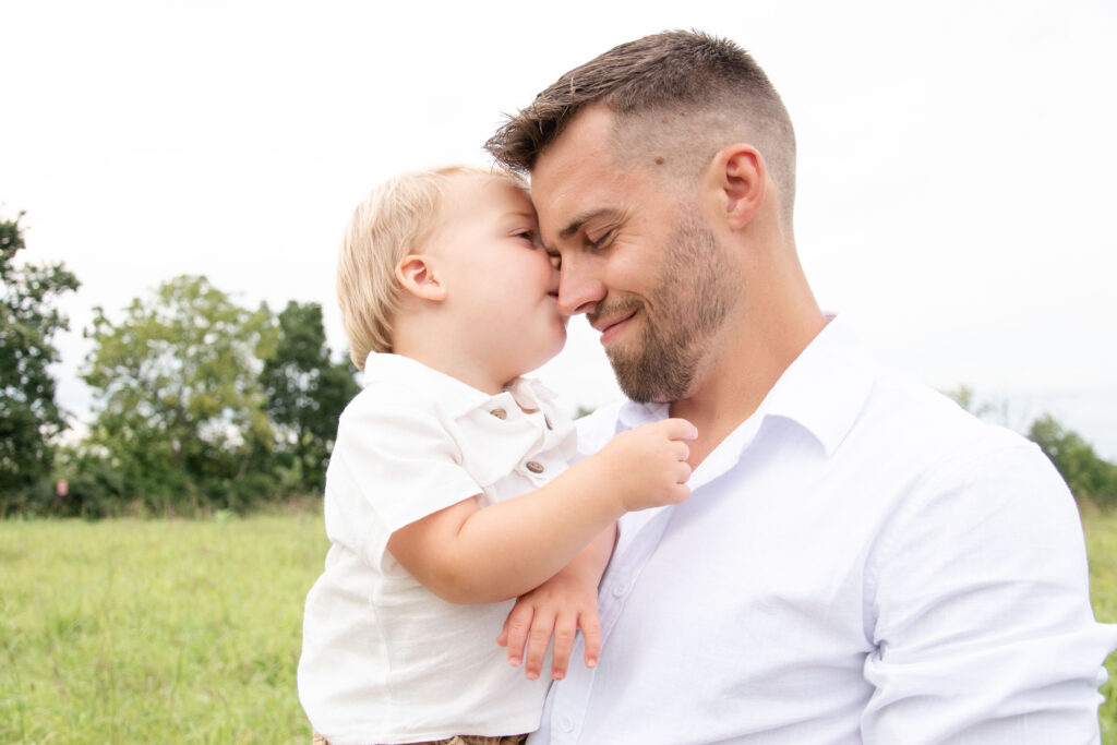 Boy kissing dads head.