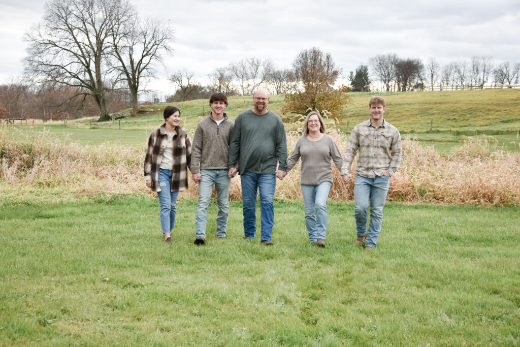 A family holding hands walking. mom, dad, two brother, and a sister.