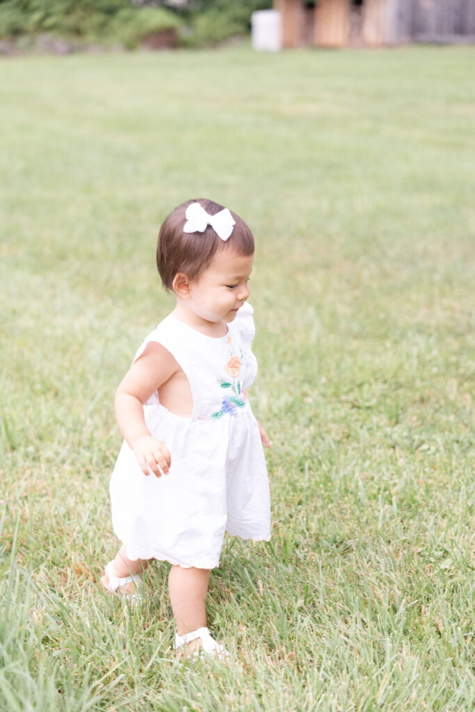 Girl walking away with a white bow in her hair.