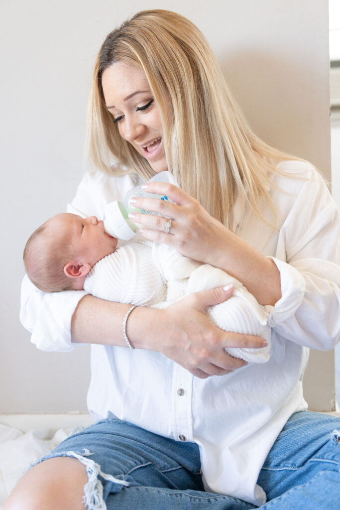 Mom preparing for newborn photos and feeding baby.  From article How to Prepare for newborn photos.