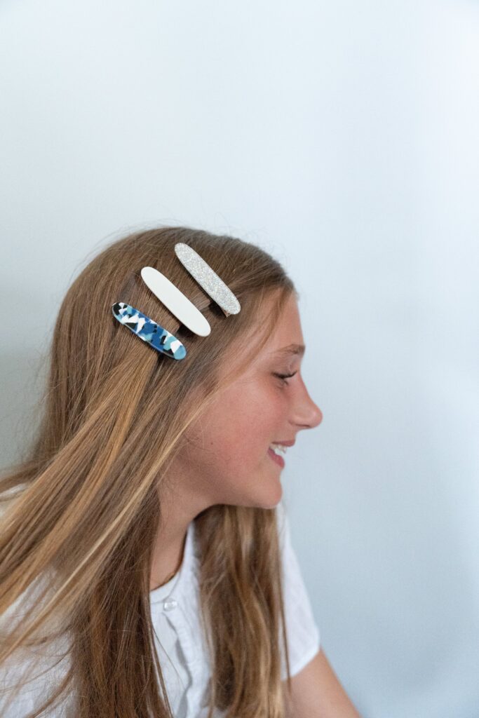 Three clips in young girls hair wearing white for what to wear to a brand shoot.