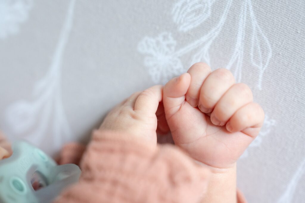 Small newborn hands in a fist. What Happens if Your Baby Cries the Whole Session?