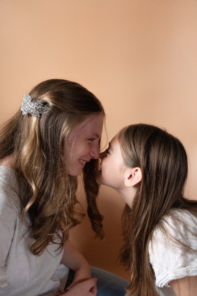 Two sisters rubbing noses. In blog about make product photos scroll-stopping.