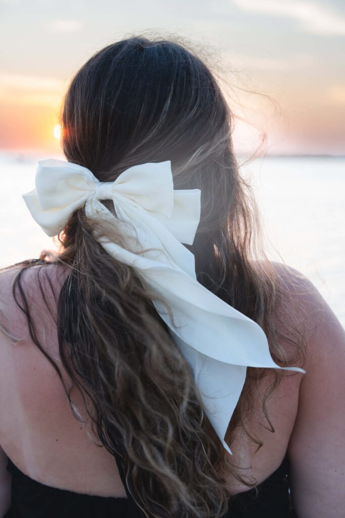 Girl at sunset with white bow in her hair. How to use brand photos.