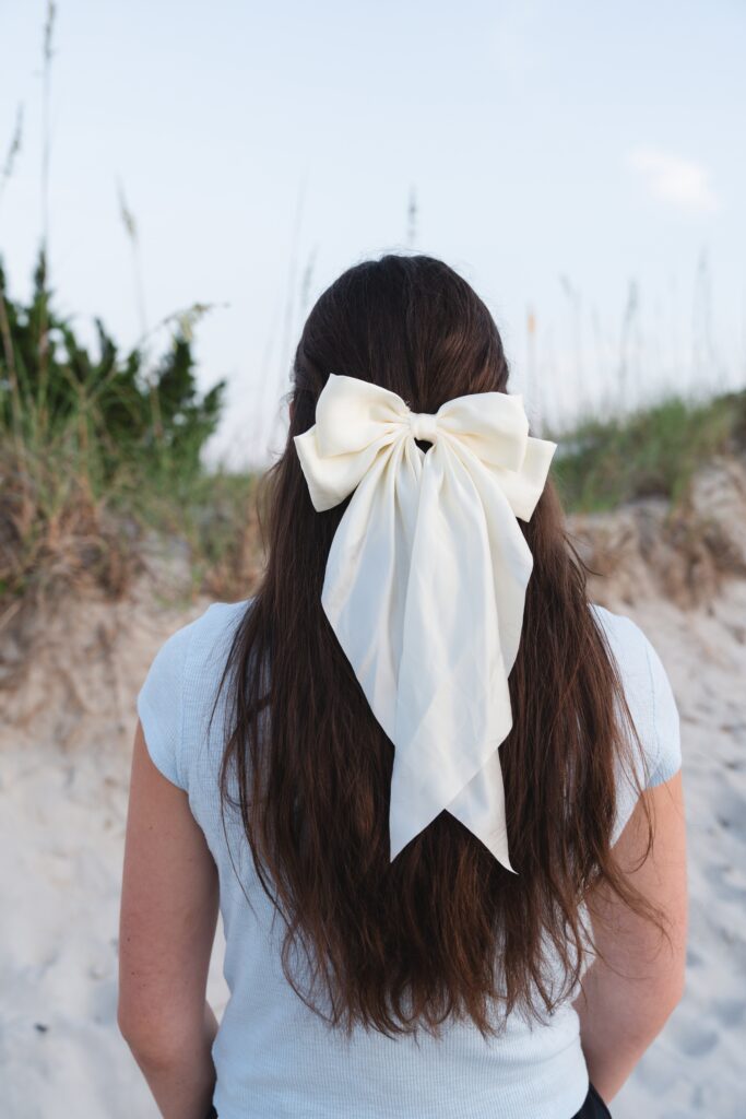White bow in girls hair accessory brand photography.