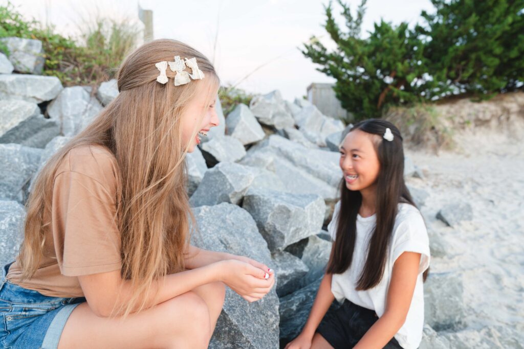 Two girls sitting and laughing. 